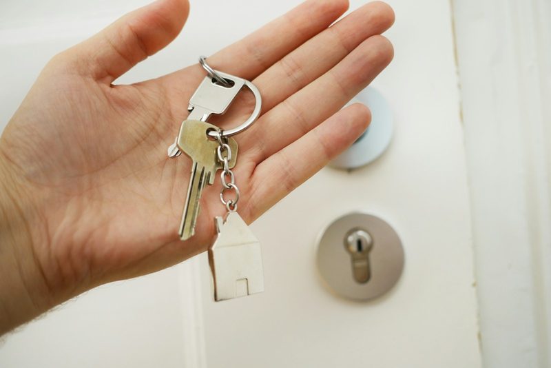 A set of house keys held in one hand